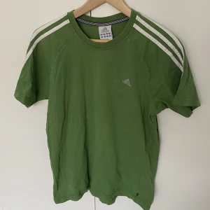 Grön T-shirt Adidas - Bästa Adidas-tishan! Har älskats av mig men är i behov en ny ägare. Väldigt fint skick, strl M och passar allt från XS-M beroende på önskad passform.