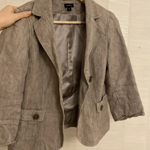 Linnekavaj  - Supersöt linnekavaj från Lindex i en grå/brun/beige färg och trekvartsärmar, perfekt nu till sommaren 💕 står strl 40 men skulle säga en S-M. Knapparna är ganska lösa men i övrigt bra skick 🫶🏻