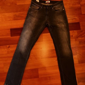 Tommy Jeans washed jeans - Ett par svart gråa tvättade brallor från Tommy Jeans. Lätt använda.