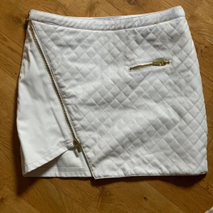 Vit kjol strl S fårn IvyRevel, fake-skinn - Vit kjol strl S fårn IvyRevel, fake-skinn. Finns en fläck fram men knappt synbar.