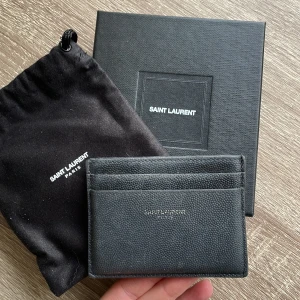 YSL korthållare - Korthållare från Saint Laurent. Denna är väl använd, se bilder för skick. Inköpt på Nathalie Schuterman, kvitto finns! Dustbag och box skickas också med.