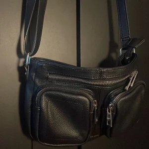 Axelremsväska  - En jätte snygg svart väska med många fickor!