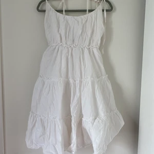 Vit sommarklänning - Så somrig och söt klänning som jag tyvärr inte får användning av längre💐💗 Ett av banden har en liten rostfläck vid rosetten, kan skicka bild om så önskas ❤️