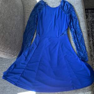 En blå klänning med lite öppet i ryggen och spetsdetaljer  (Frakt tillkommer)
