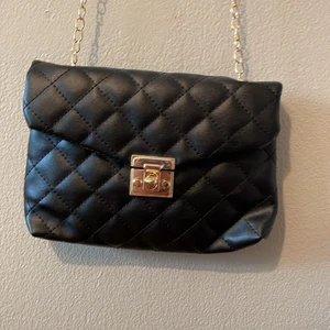 Svart väska - En svart snygg väska med guldkedja 