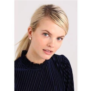 Dyrberg/Kern örhängen Layla roseguld pläterade rosé guld - Dyrberg/Kern örhängen "Layla". Inplastade.  Roséguldpläterade med svarta emaljringar. "To travel is to live" stämplat runt om. Ca 10mm i diameter.