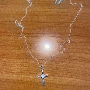 Silverfärgad sterling silver med kors - Fint kors i sterling silver , enkel och simpel samt oanvänd.