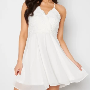 Studentklänning - Vit klänning som slutar ovanför knäna. Perfekt till studenten! Använd endast en gång så är i nyskick.