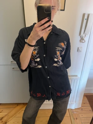 Mönstrad bomullsskjorta med draktryck - Mönstrad bomullsskjorta köpt second hand i San Francisco, med drak-tryck