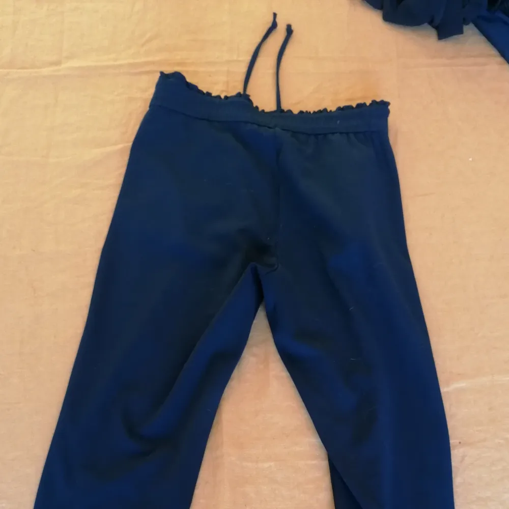 Slack/kostymbyxa i polyester material. Marinblå och från Jacqueline de Yong. Små volanger i fickor och midja. . Jeans & Byxor.
