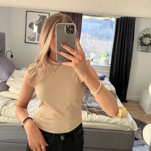 Beige topp - Superfin beige topp med volangärmar. Fint skick, säljer då jag inte får användning för den. Storlek M men är som en S