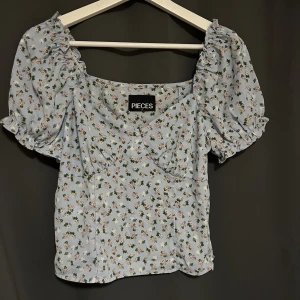 Blommig blus - Söt blommig blus ifrån Pieces, storlek S, med dragkedja i sidan. Aldrig använd med tagit bort lapparna. Köpt för 250, säljer för 100+frakt 