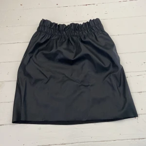 Minikjol - Minikjol i läderimitation från BikBok med mudd vid midjan i storlek S