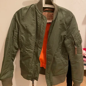 Bomberjacka, xs - Grön, orange inuti. Storlek xs. Inga fel på den. Ej använd speciellt mycket. 