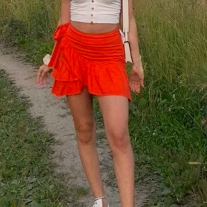 Röd sommar volangkjol - En super söt röd volang kjol med knytband på sidan ifrån topshop ! Den är i storlek 36 men passar 34 också, har en dragkedja på sidan 