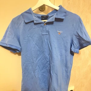 Gant Blå pikétröja stl s - Vacker blå pikétröja i nyskick, använd ett fåtal gånger. Tröjan är i 100% bomull och bekväm att ha på sig. Fungerar lika bra på jobbet som på festen! Nypris är 799kr