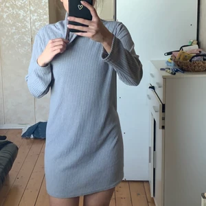 En grå stickad långärmad klänning  - En grå mysig klänning från okänt märke då det inte finns någon lapp i den, storlek s/m 