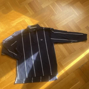 Fred Perry Tröja - Vintage Fred Perry Half Zip i marinblå med vita ränder i fint skick. Första bilden är referens på passform.