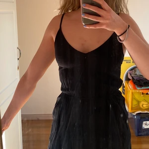 Svart jumpsuit - Säljer min svarta jumpsuit från H&M då den blivit för liten! Sparsamt använt så skicket är som i nyskick! Storlek: 34