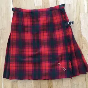 Äkta skotsk kilt i 100% ull. Sparsamt använd - perfekt skick. Längd 53 cm. Storleken ändras med läderflärparna i sidan.