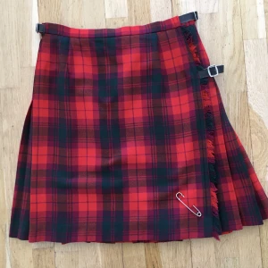 Äkta kilt - Äkta skotsk kilt i 100% ull. Sparsamt använd - perfekt skick. Längd 53 cm. Storleken ändras med läderflärparna i sidan.