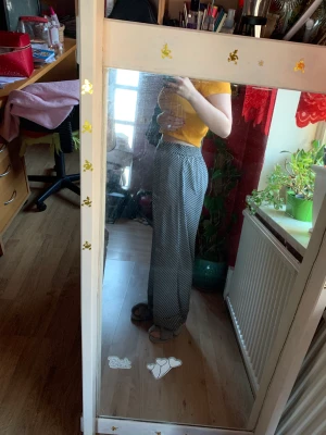 svart och vita byxor - tunna byxor som passar bra till sommaren. Är som nya. Är väldigt vida och luftiga. Men fastnar lite på benen ibland som man ser i sista bilden. Sydda längst ner för att de var för långa på mig, jag är ca 165 cm lång. Kan ta bort stygnen om du är längre.