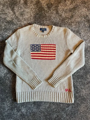 Ralph Lauren flagg tröja  - Hej, säljer en snygg Ralph Lauren grå tröja i storlek L ( 14-16 ) skulle säga att den är som typ en xs
