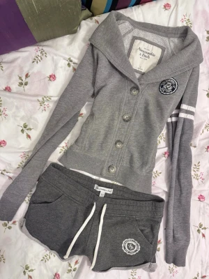 Abercrombie & Fitch low rise set  - perfekt set, sällsynt och svårt att få tag på  i nyskick 🤍shorts: midjemått rakt över 35/36 (justerbara) längd ~ 21  tröja: bredd 39, längd 48 cm skickas samma dag som köpet men inte med Bring 