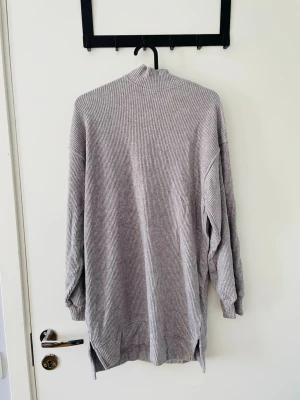 Grå ribbad top/ tröja från Bershka - En grå ribbstickad längre polotröja från Bershka. Håller värmen och passar perfekt till stl. S. 