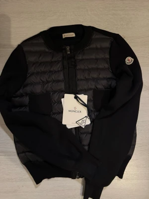 Moncler cardigan - Hejj! säljer nu min fina moncler cardigan, den är varsamt använd utan defekter och därmed i mycket bra skick. Säljer då jag vill ha en i likadan fast i en annan färg. Det går såklart att skanna qr koden på ”industery tagen”. En perfekt cardigan för våren och sommaren. Den är i storlek 1 vilken motsvarar S men den passar mig som brukar ha XS. Bara att höra av er vid frågor!💗💗prislappar och Moncler påse medföljer💗