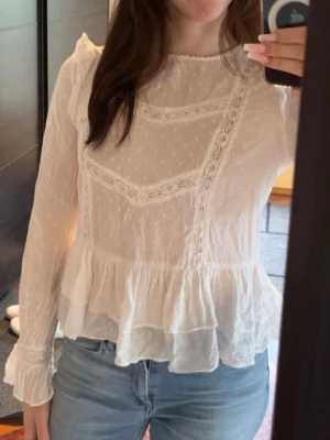 Vit Zara blus - Super söt vit långärmad blus från Zara med fina detaljer och volang nedtill. Använd men inga defekter, säljer pga tyvärr blivit för liten