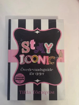Stay Iconic: Överlevnadsguide för tjejer - Boken 'Stay Iconic: Överlevnadsguide för tjejer' av Tilda Törnqvist är en peppande guide för unga tjejer. Omslaget har svartvita ränder, rosa detaljer och färgglad text. Perfekt för dig som vill boosta självförtroendet och få tips om livet. Inbunden bok.