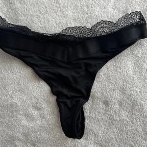 Svarta stringtrosor med spetskant - Cheyenna Thong. Ny oris 199kr.