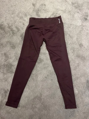  DFYNE impact leggings ”Espresso”  - Säljer de trendiga DFYNE impact leggings i färgen ”Espresso”. Det är i storlek medium. Det har en skrunch baktill som formar rumpan väldigt fint, samt en resor som håller tightsen uppe. De är tillverkade i 90% nylon och 10% elastan, vilket gör att det håller in allt men sitter väldigt bekvämt. Perfekta för gymmet, promenader eller till vardags. annan träning. Använda endast en gång!!! Köpta för 560kr 