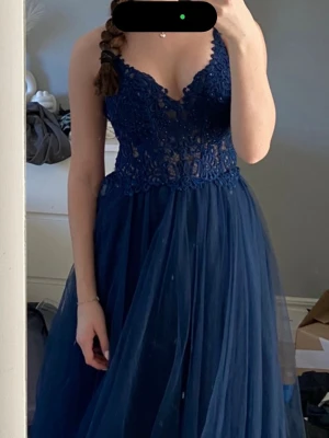 Blå balklänning från mascara  - Marinblå balklänning med knytning i ryggen. Passformen är tajtare i midjan och mer utsvängd nertill. Sitter som en ”inbyggd bh” på insidan av klänningen (se bild nr 4). Den är ändast använd en gång. Köpt för 2300 kr från mascara. Jag är 160 cm lång och för mig går den ner till marken utan klackar. Den har knytning i ryggen så man väljer själv hur den ska sitta. Inga synliga defekter, ser alltså helt ny ut.  Om du har funderingar är det bara att höra av sig. Pris går att diskutera😊