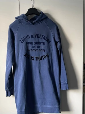 Blå hoodies Zadig & Voltaire - Blå hoodies från Zadig & Voltaire med tryck framtill i svart text. hoodies har huva, lång ärm och en avslappnad passform. Perfekt för en chill och cool look.