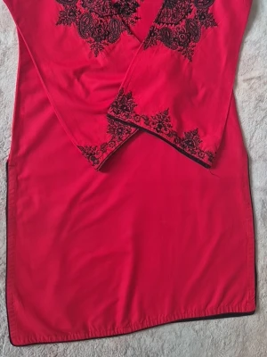 Red tunic, size S - Red tunic with black embroidered details. The tunic has long sleeves and a round neckline with a beautiful design at the front. The embroideries are located around the neck, on the sleeves and along the lower edge of the cuffs. The tunic has a straight fit. Arm length: 46 cm  Shirt Length: 84 cm Shippping same day if you order during opening hours of post office 