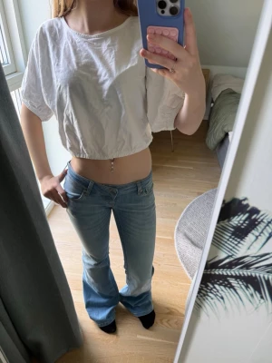 Vit poffig magtröja - En vit lös t-shirt med ”shrunched” kanter vid mage och armar. Passar riktigt bra till jeans och jeansshorts. Kan sänka pris vid snabb affär.