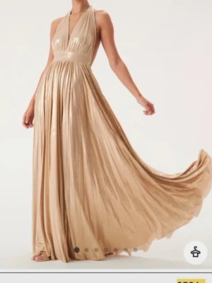 Guldig långklänning med öppen rygg - Guldig balklänning från Goddiva. Använda en gång. Den är uppklippt så den passar mig som är 168 cm och då går den ner exakt till marken utan klackar💕