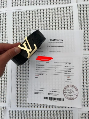 Svart Ls Von bälte med guldspänne - Säljer ett svart LoVuon bälte med klassiskt rutigt mönster och stort L-spänne i guld. Bältet har exklusiv känsla och är tillverkat i skinn med tydliga detaljer. Perfekt accessoar för att lyfta din outfit.