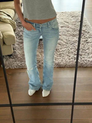 Ljusblå bootcut jeans med slitningar - Såå snygga jeans från Gina som tyvärr inte kommer till användning, endast använda en gång! storlek 34💕