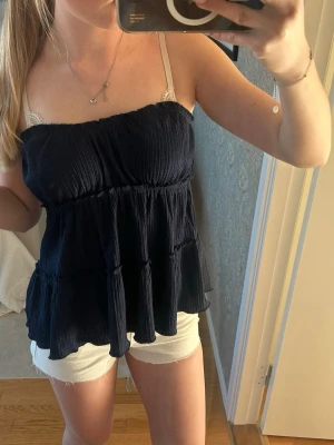 Bandå-topp med volang  - säljer en super snygg mörkblå bandå-topp från cubus som hade band men klippte bort de, är i super bra skick och knappt använd! I storlek 170 men är som Xs/S, den är i jätteskönt material och stretchig högst upp!💕