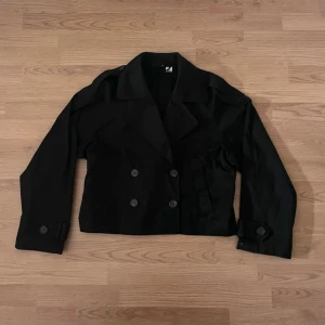 Trenchcoat  - Svart kort trenchcoat. Aldrig använd. 