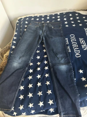 Blåa jeans - Blåa Levis jeans storlek M med en litern grishig stil