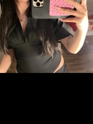 Svart omlottopp med djup v-ringning - Snygg svart omlottopp. Den är i xs men passar mig som har S och är lite bredare. Jätte snygg under vita byxor!! Jätte fin tröja verkligen, skriv för fler bilder! 