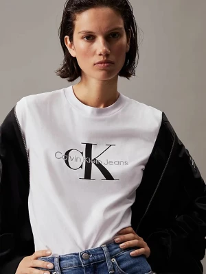 Vit Calvin Klein Jeans t-shirt - Snygg vit t-shirt från Calvin Klein Jeans med stor svart CK-logga och text på bröstet. Klassisk rund halsringning och korta ärmar. Tillverkad i mjuk bomull för en skön och avslappnad look. Perfekt till jeans eller shorts för en clean stil.