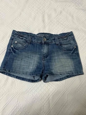Vintage y2k blå jeansshorts från monday jeans  - Snygga blå jeansshorts från monday med klassisk femficksdesign och slitna detaljer framtill. Shortsen har knapp- och dragkedjestängning samt bakfickor med lock och knapp. Perfekta för varma dagar och enkel att matcha med allt.