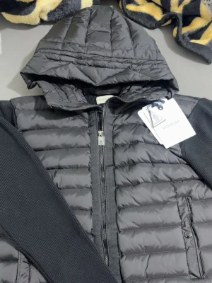 Svart jacka från Moncler (GÅR ATT SKANNA!!!) -  Svart stilren jacka med vadderad front och huva för clean och modern fit 😮‍💨🔥 Bekväma ribbade ärmar och detaljer som gör den perfekt både till vardag och kväll 👌 Passar S/M🔥