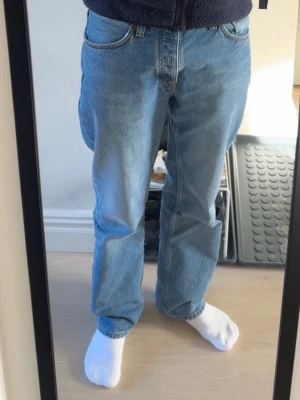 Nudie Rad Rufus Indigo Blues - High-waist regular fit med rak passform. Modell Rad Rufus Indigo Blue från Nudie Jeans. Gjorda från ekologisk bomull. Endast tvättade ett fåtal gånger och mycket gott skick. Nypris 1600. Storlek 31/32. 