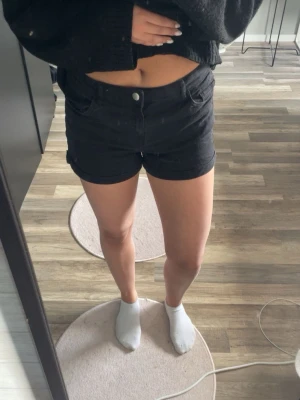 Svarta jeans shorts - Säljer ett par svarta jeans shorts med knapp och dragkedja framtill. Jättesnygga på sommaren!